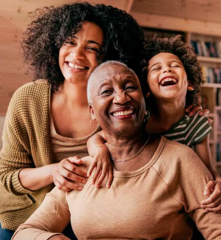 Mulher sorrindo de olhos fechados e dando um abraço em si mesma e ilustração com o texto: Outubro Rosa - um mês de cuidado com a saúde da mulher